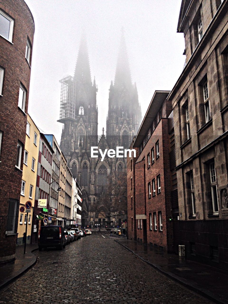 Street amidst buildings leading to cologne cathedral