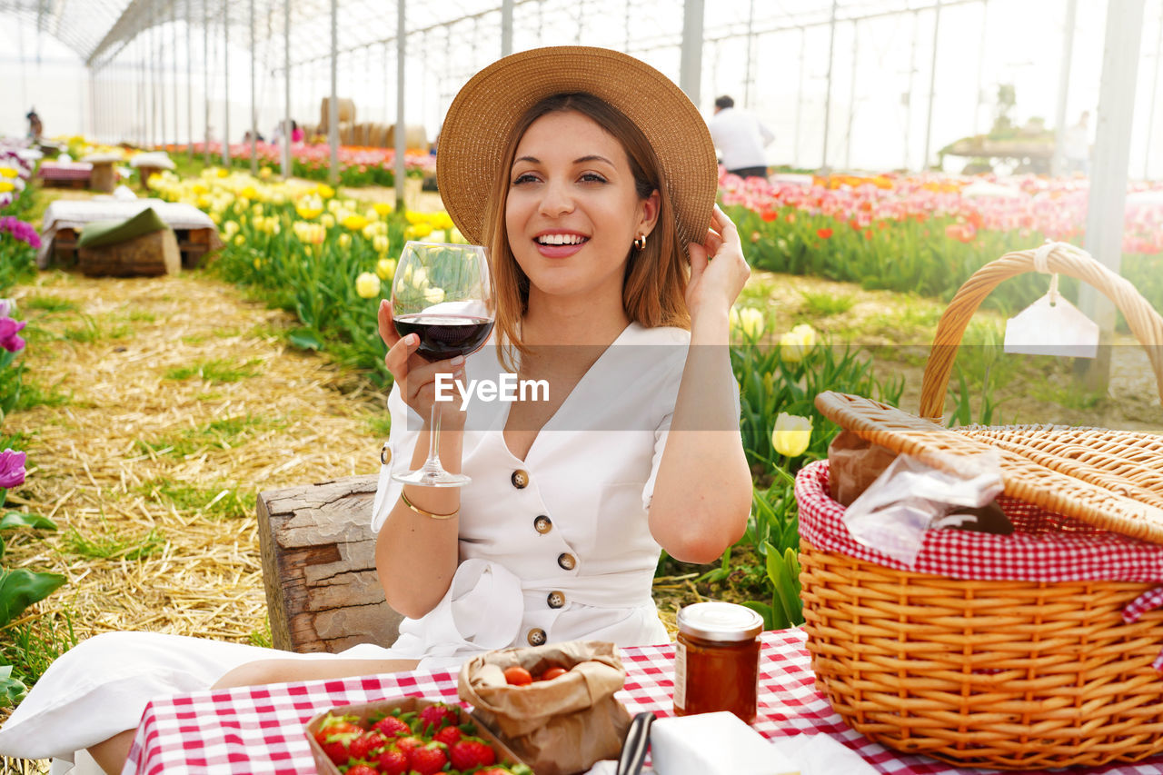 Attractive young woman having appetizer among tulip flowers