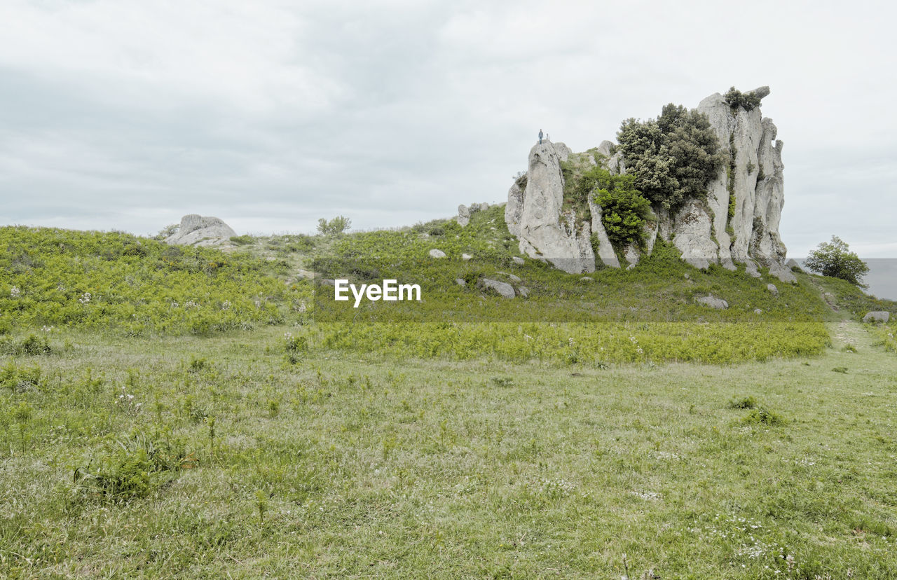 Scenic view of rocks on field against sky