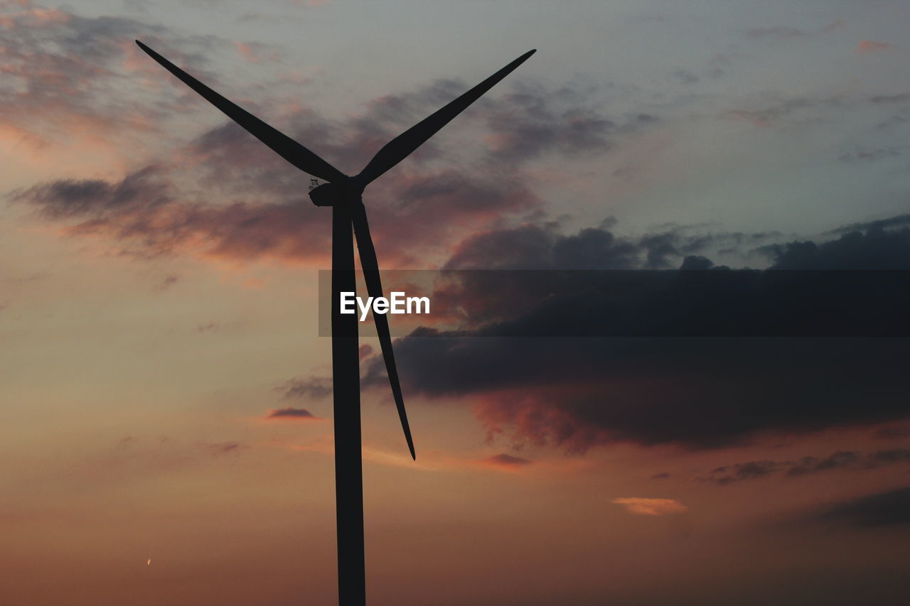 Low angle view of silhouette wind turbine against sky during sunset