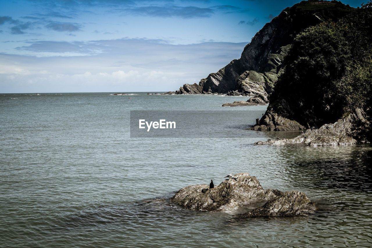 Rock formation in sea against sky