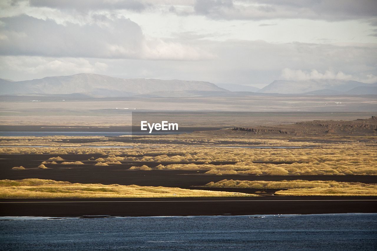 Scenic view of landscape against cloudy sky