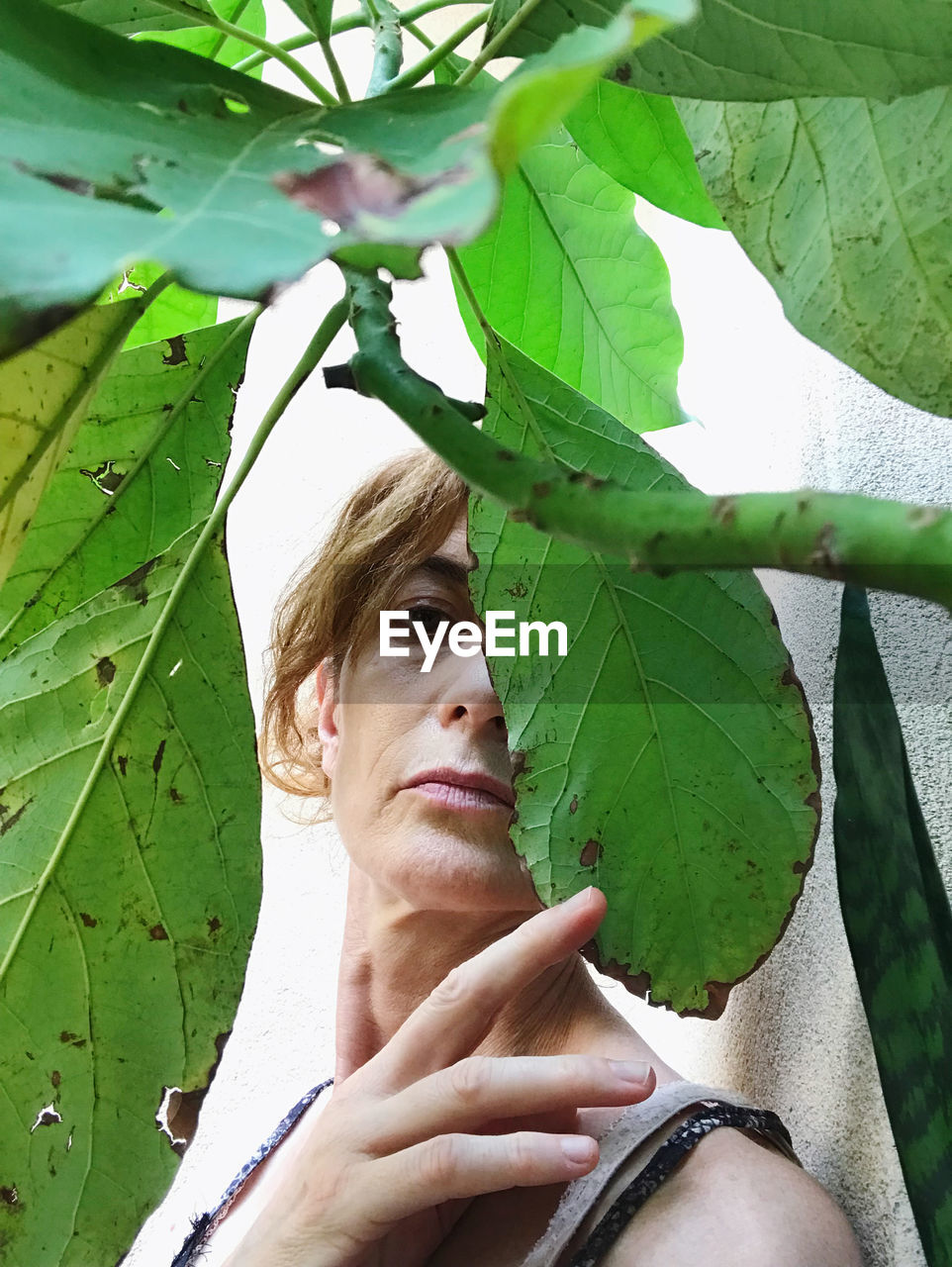 CLOSE-UP PORTRAIT OF YOUNG WOMAN WITH LEAVES