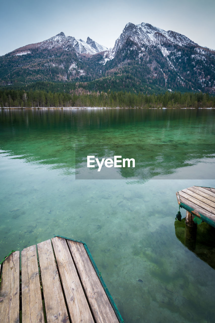 Scenic view of lake by mountains against sky