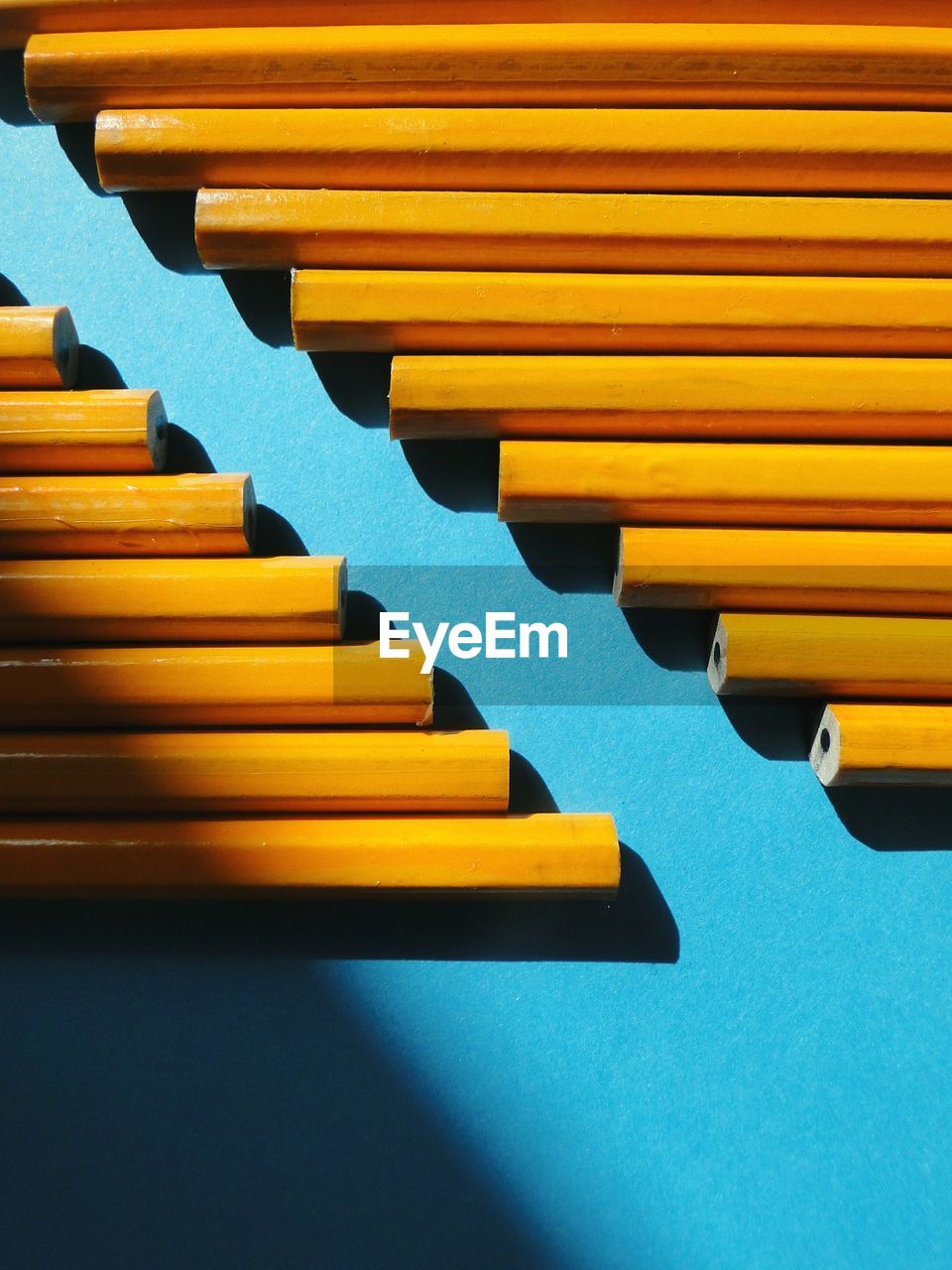 Close-up of yellow pencils on blue table