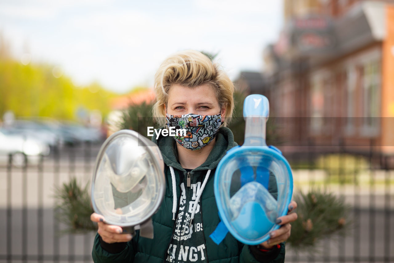 Young girl holding masks for snorkling.