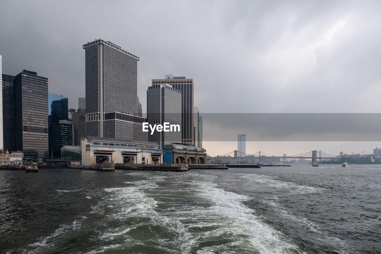 SEA BY BUILDINGS AGAINST SKY IN CITY