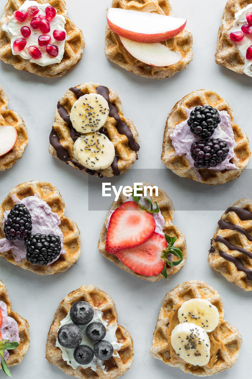 Mini heart shaped waffles with various toppings of spreads and fruit.