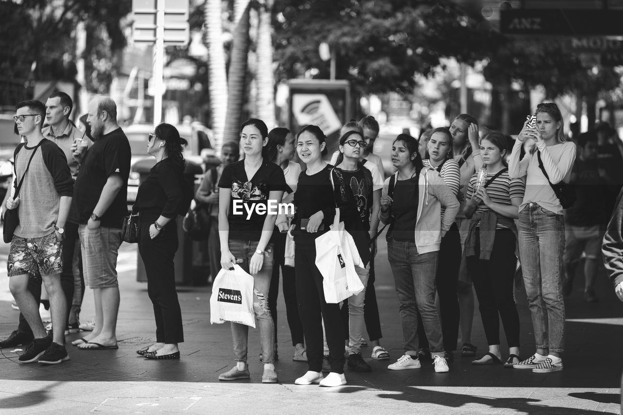 GROUP OF PEOPLE ON STREET IN CITY