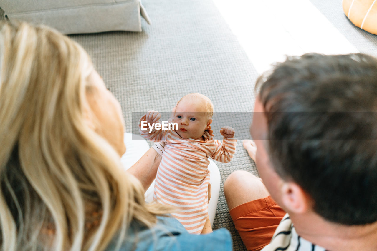 View from above of a mom and dad holding their newborn daughter