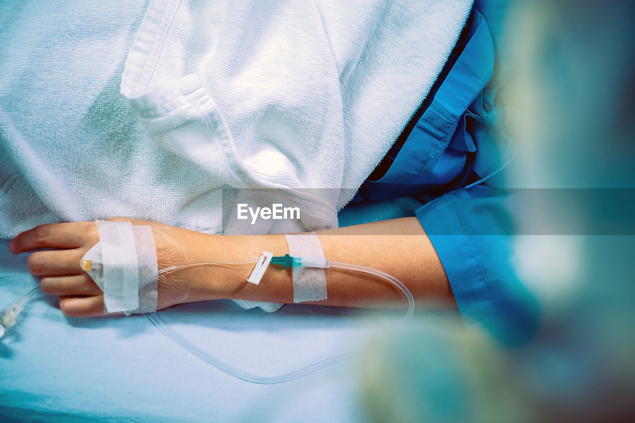 Close-up of woman hand with medical equipment on bed