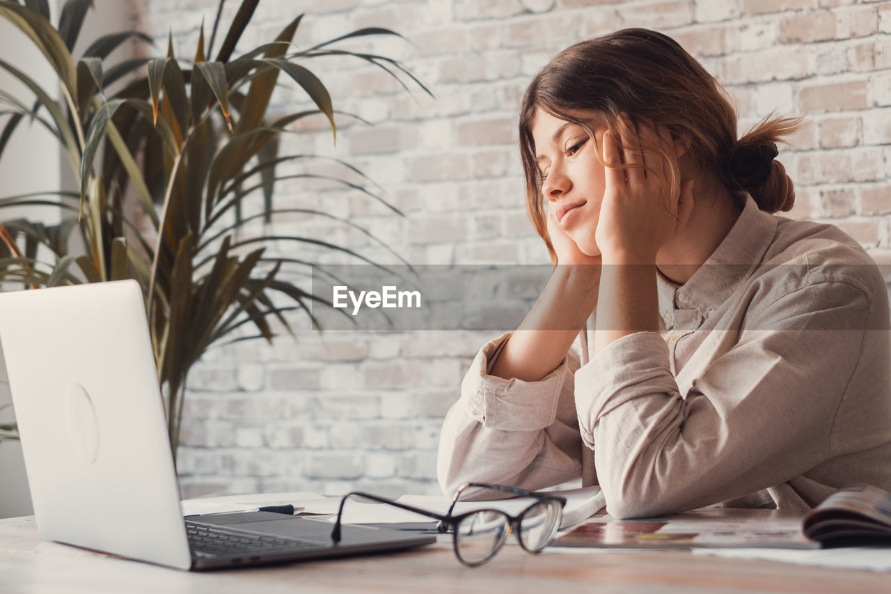 Teenage girl using laptop at table