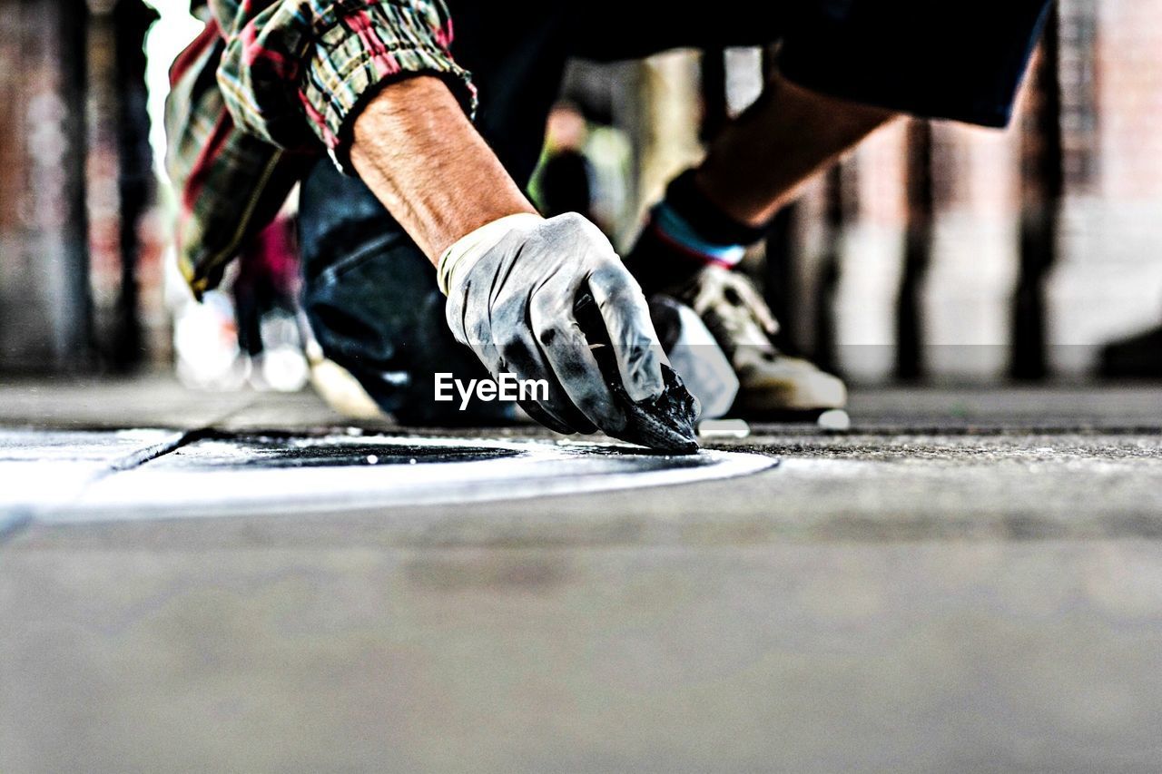 Cropped image of hands with glove making street art