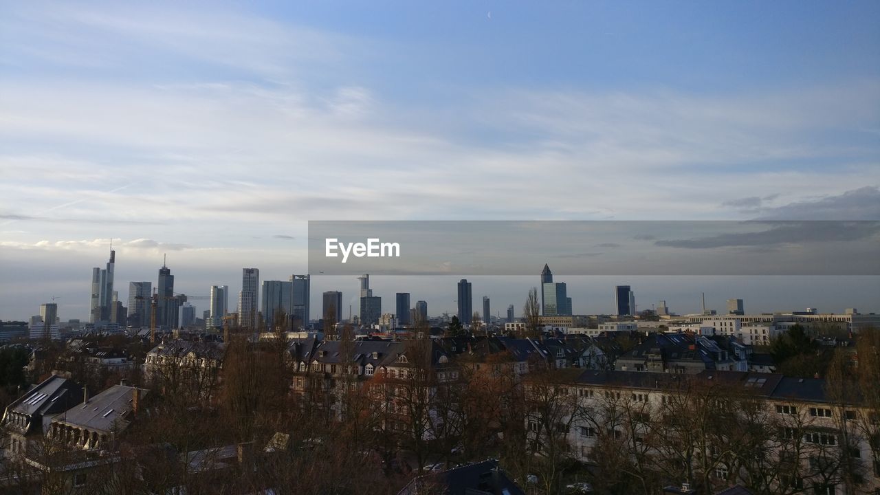 View of cityscape against cloudy sky