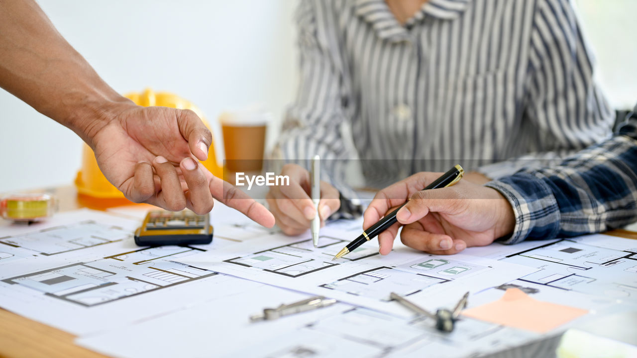 midsection of businessman working at table