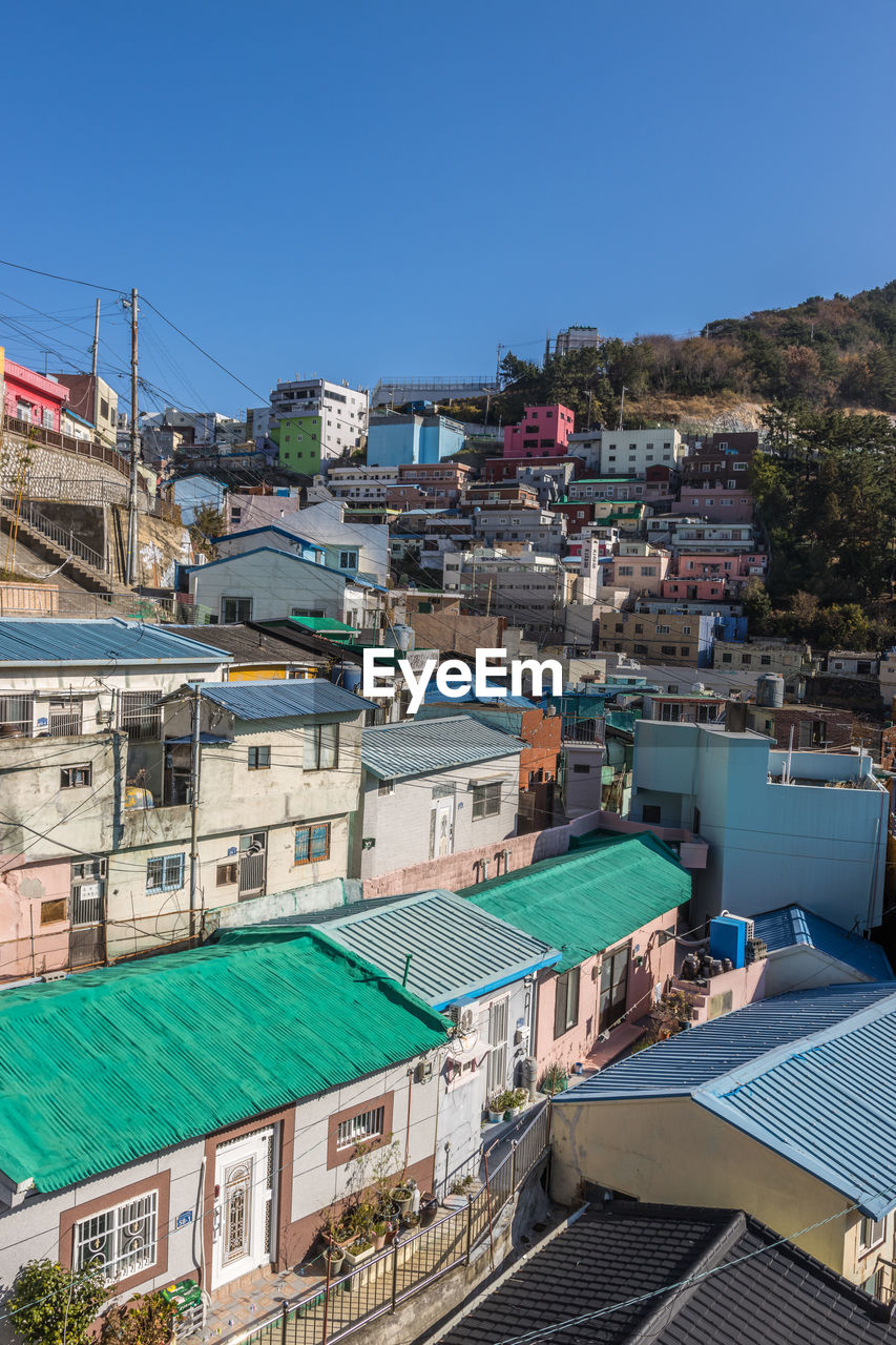 architecture, building exterior, built structure, building, city, town, water, vacation, nature, sky, house, residential district, clear sky, travel destinations, high angle view, roof, travel, sunny, land, sea, tourism, no people, day, blue, outdoors, cityscape, urban area, transportation, aerial photography, community, environment, dock, sunlight