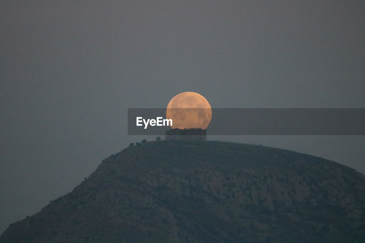 LOW ANGLE VIEW OF MOON AGAINST CLEAR SKY