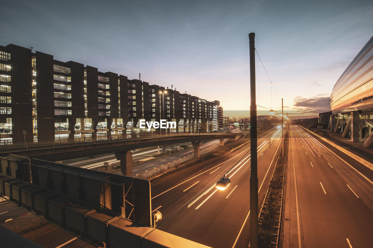 Light trails on road against sky at sunset