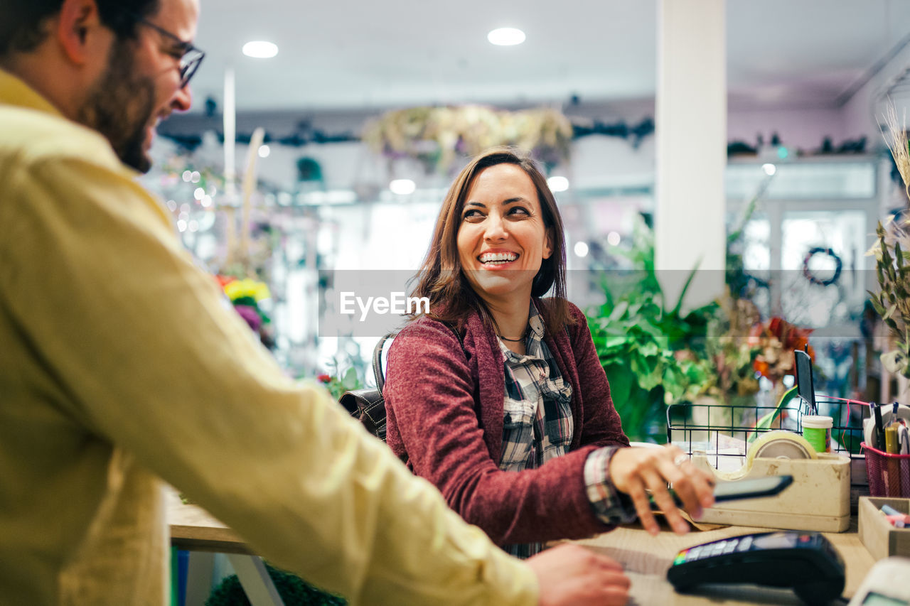 PORTRAIT OF A SMILING YOUNG COUPLE IN STORE