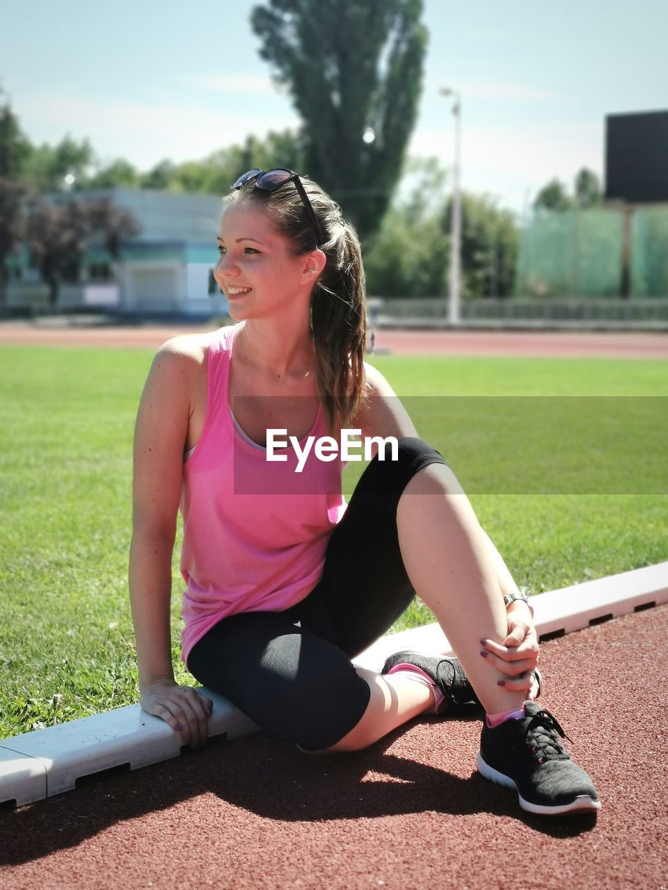 Young woman sitting on sports track