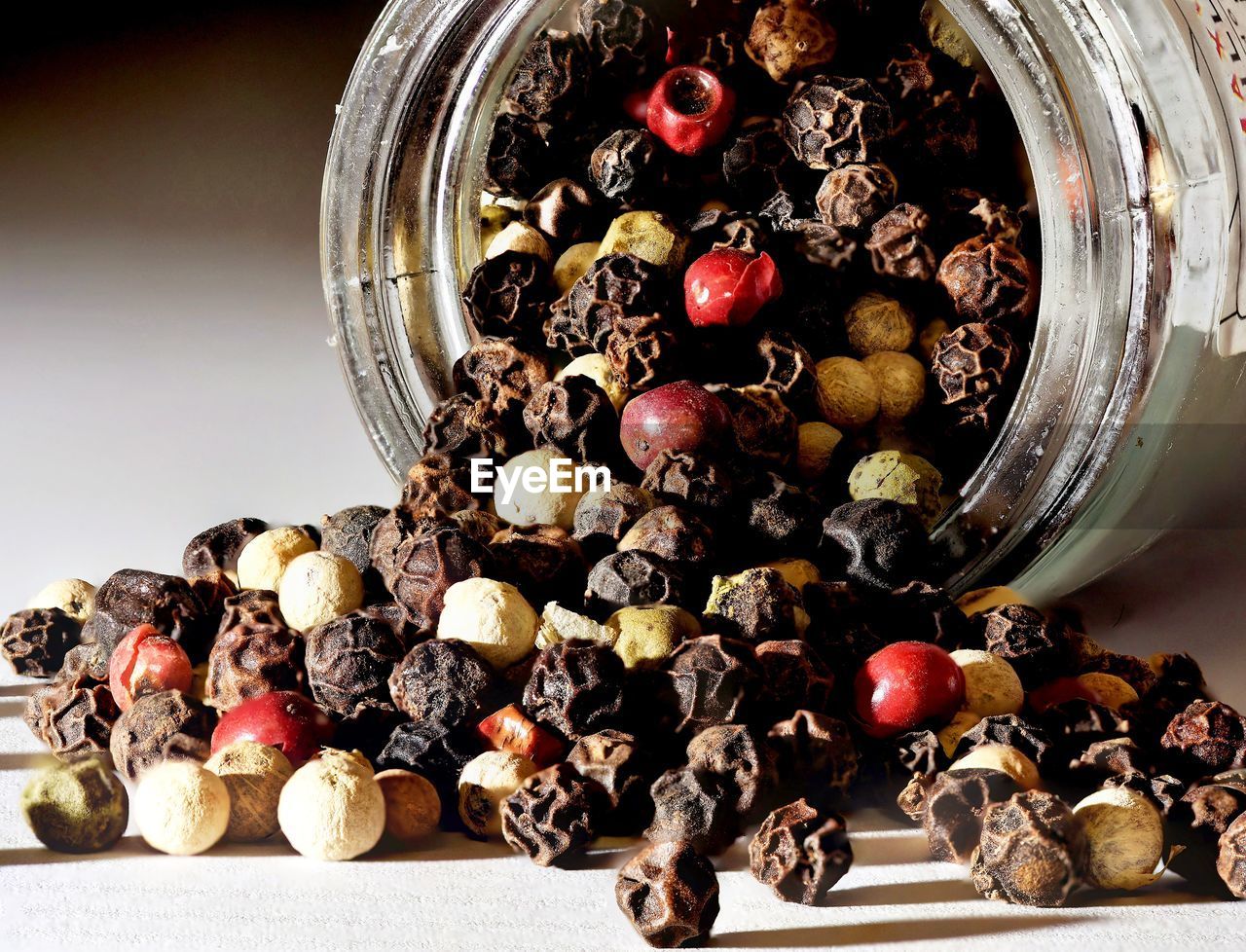 Close-up of dried berries spilling from jar on table