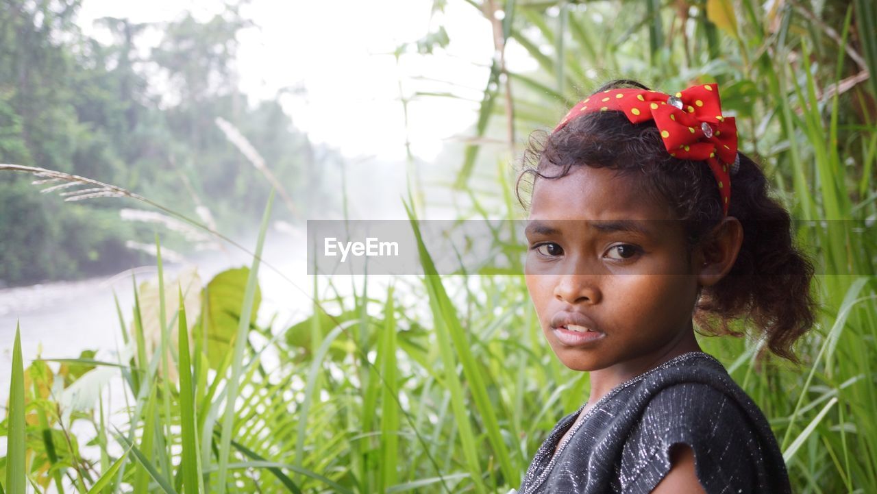 Side view portrait of girl by grass