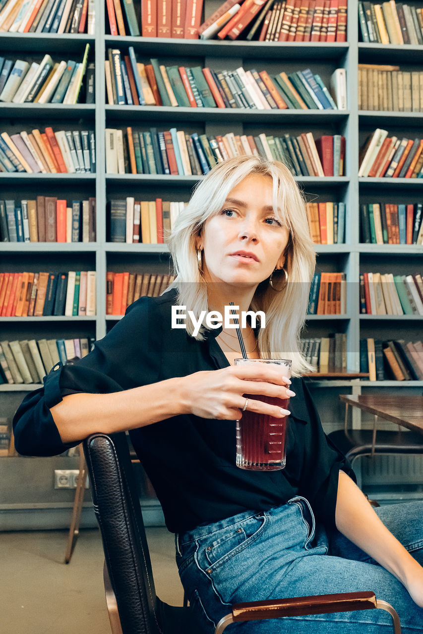 YOUNG WOMAN SITTING ON BOOK