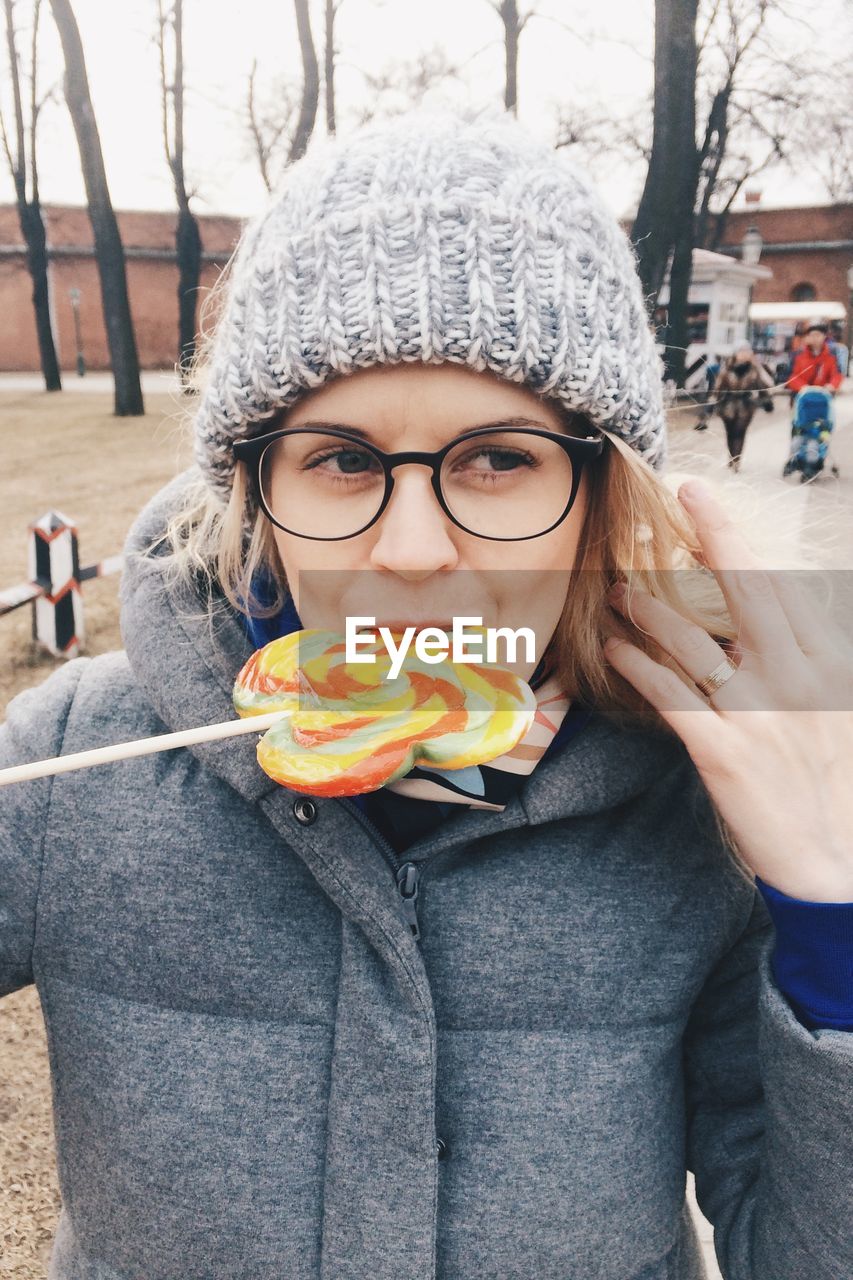 Woman looking away while eating lollipop