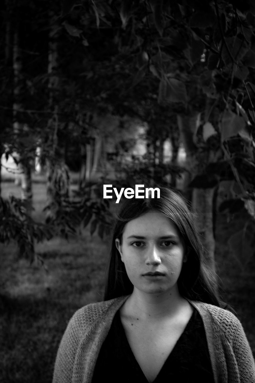 Portrait of young woman standing in park