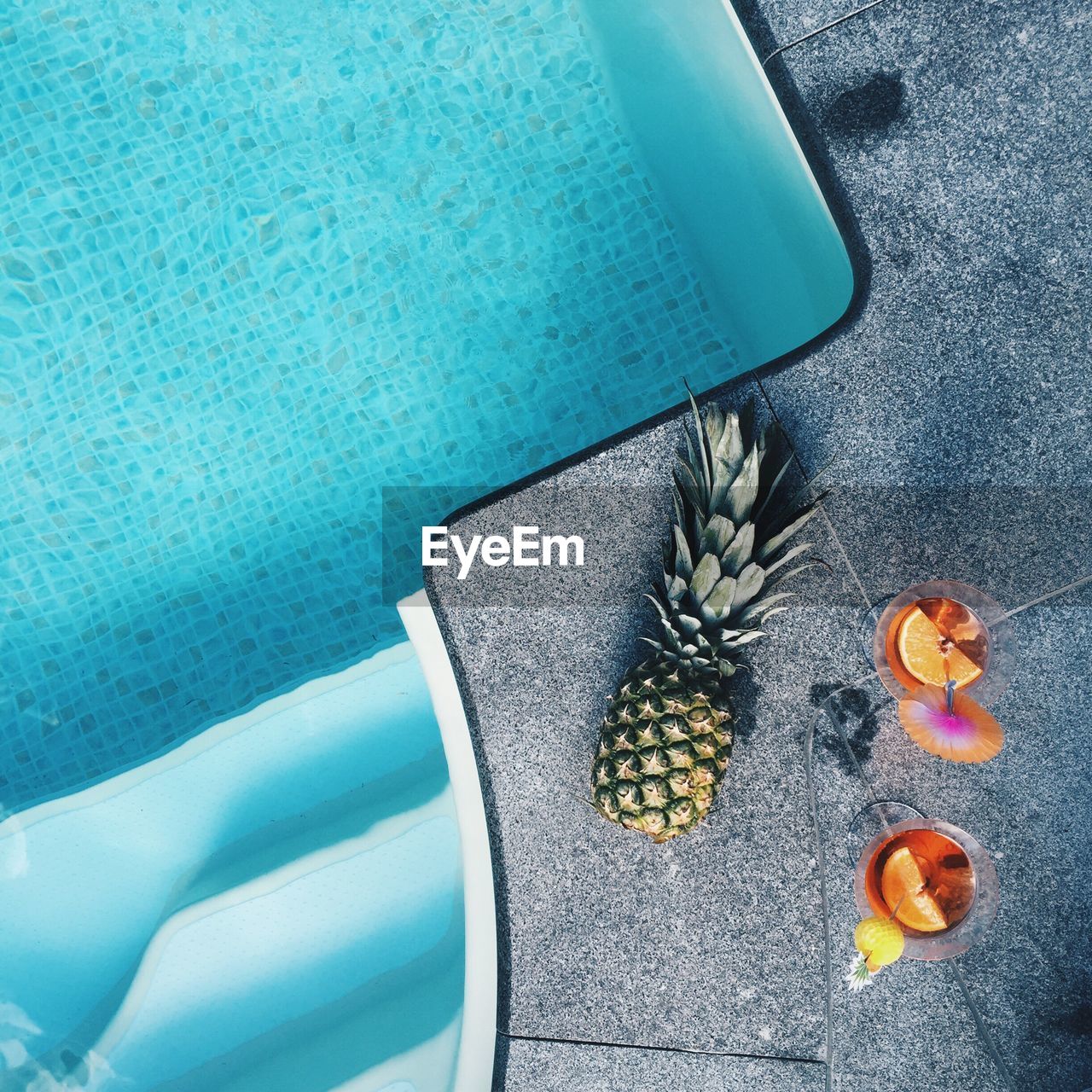Directly above view of pineapple and drinks at poolside