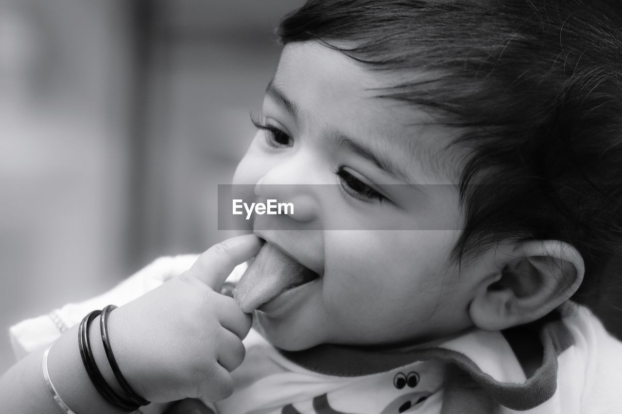 Close-up of cute smiling baby boy looking away