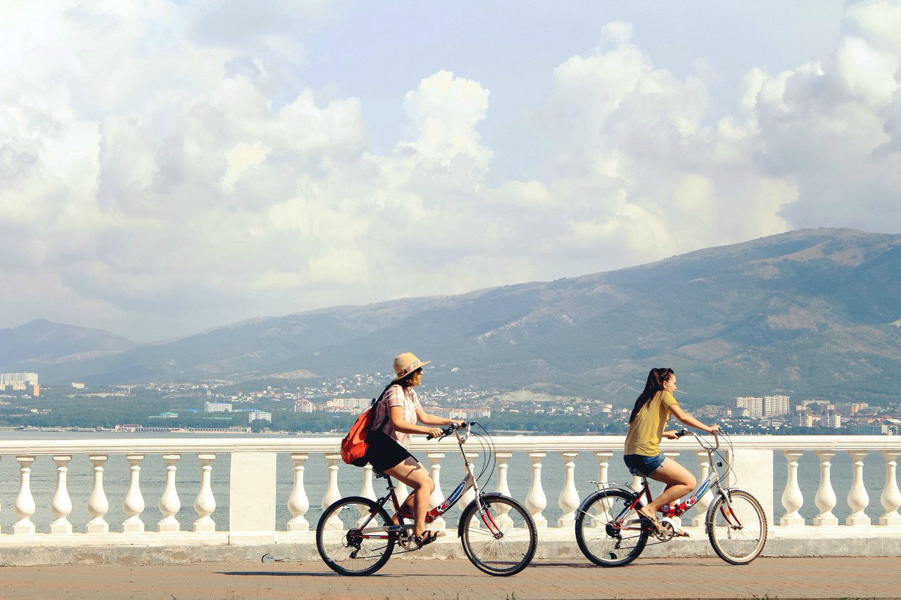 BICYCLES ON BRIDGE AGAINST MOUNTAINS