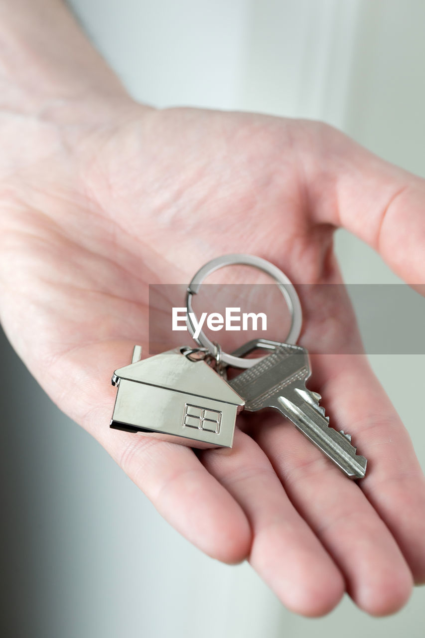 CLOSE-UP OF HUMAN HAND HOLDING EYEGLASSES