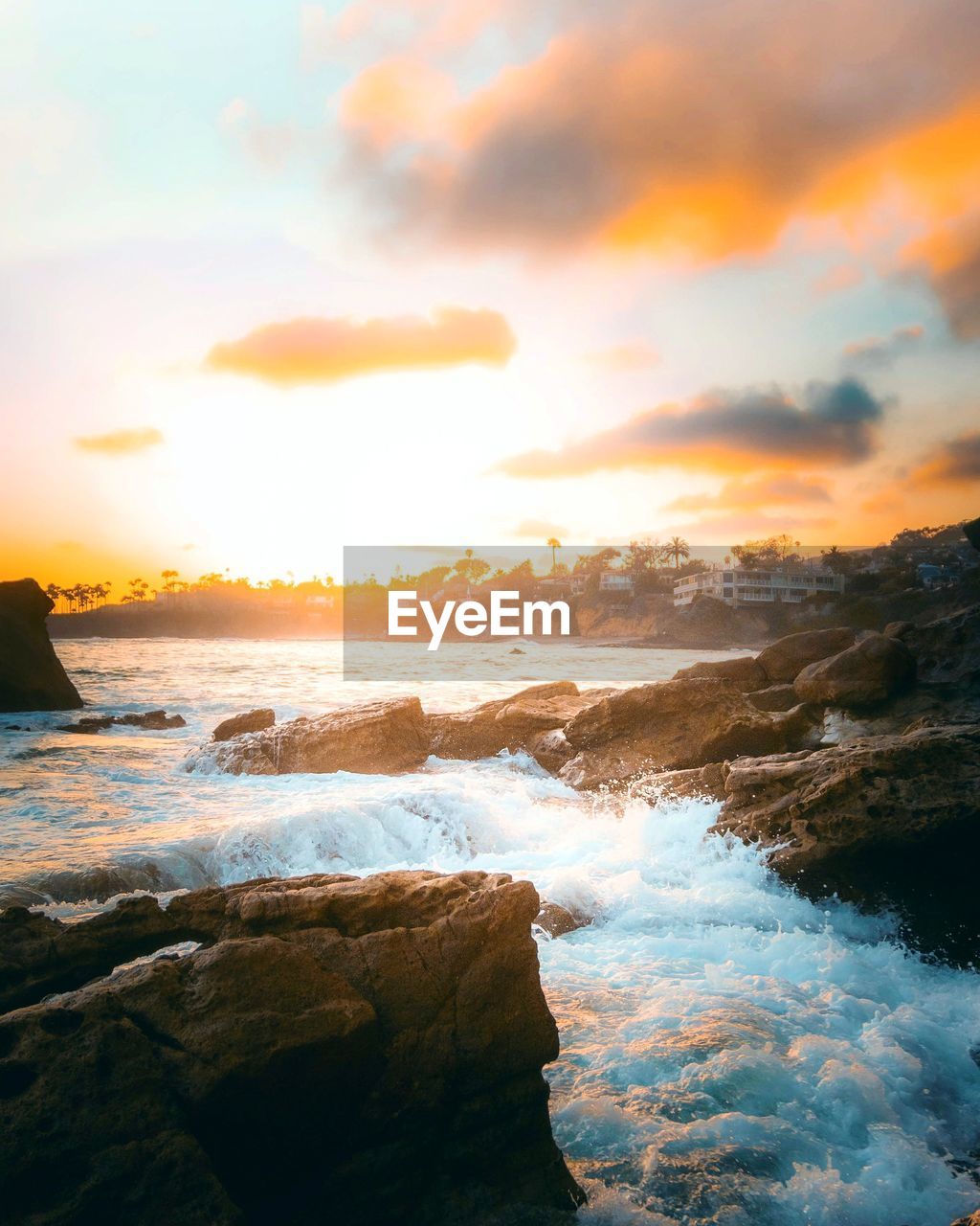 SCENIC VIEW OF ROCKY BEACH AGAINST SKY DURING SUNSET