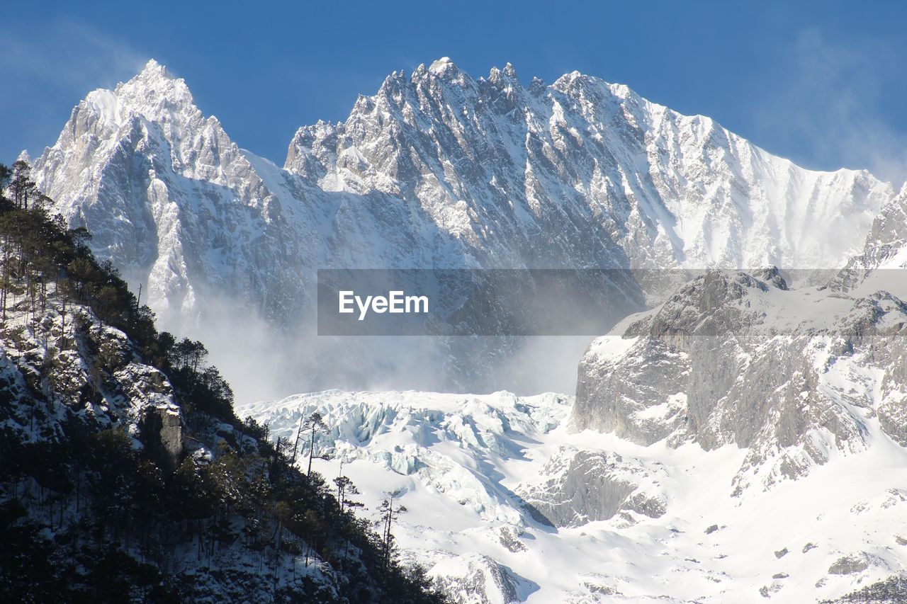 Fog over snowcapped mountain range