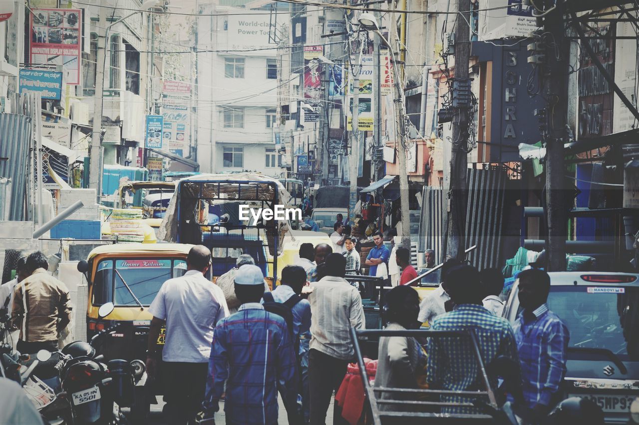 People on city street against buildings