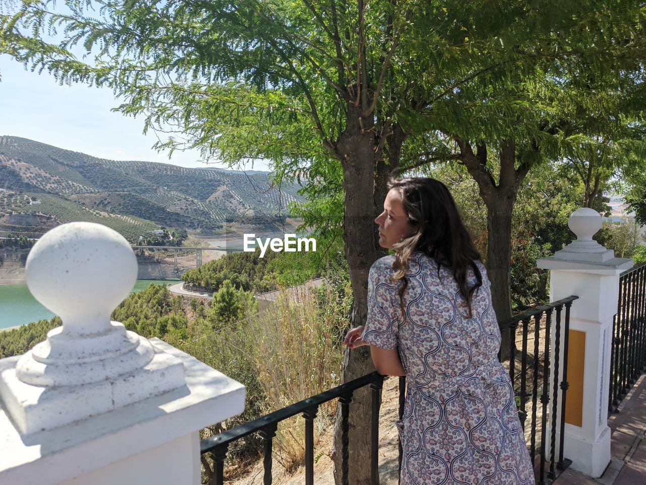 Woman standing by railing against mountain