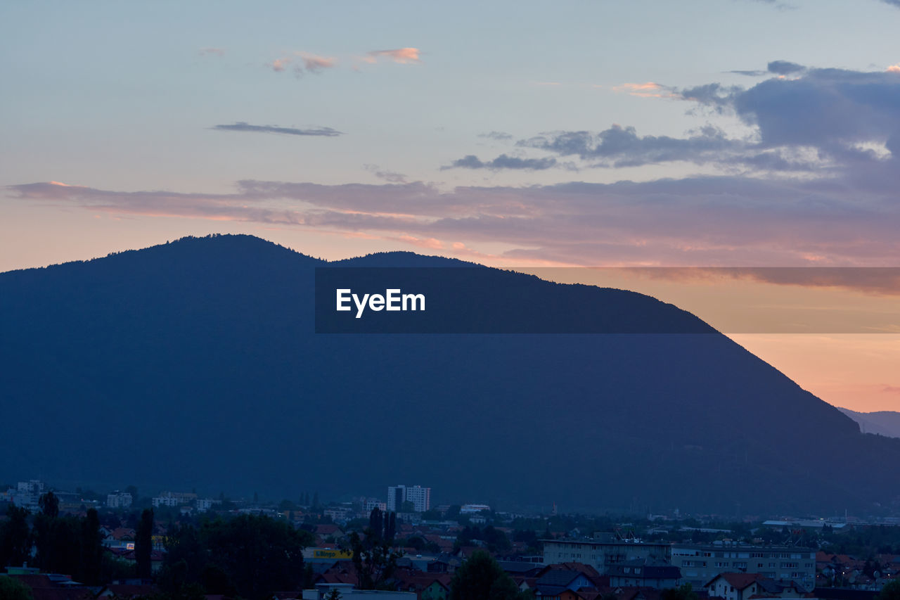 VIEW OF TOWNSCAPE AGAINST SKY AT SUNSET