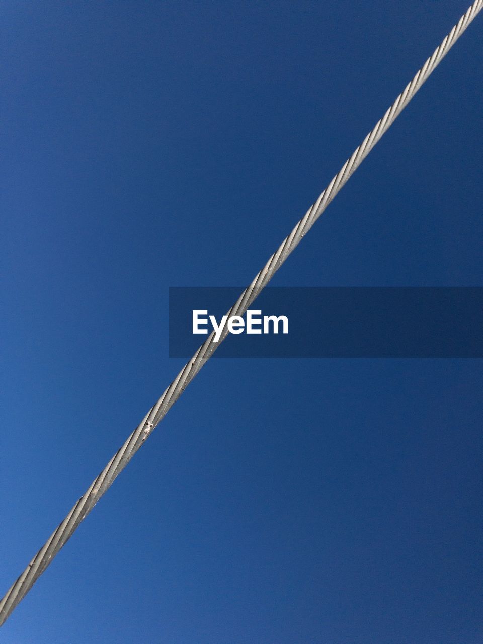 Close-up of a electric wire against clear blue sky