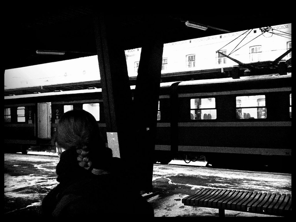 Rear view of woman sitting at railroad station