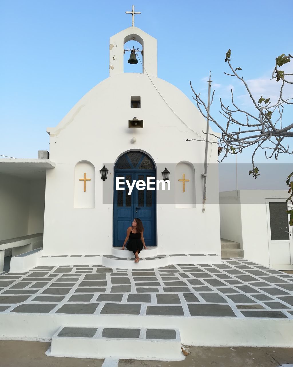 Full length of mid adult woman sitting by church