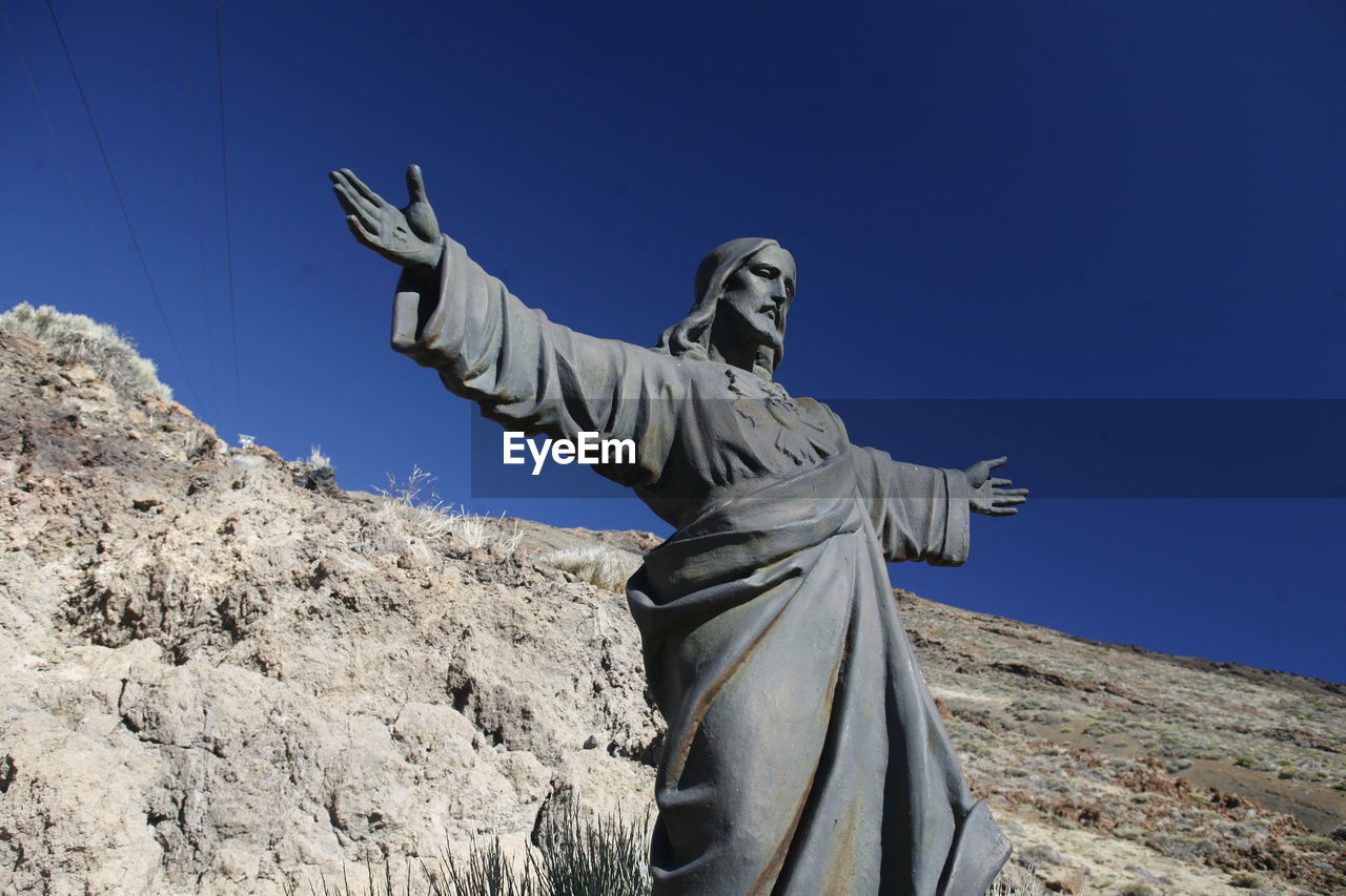 Low angle view of jesus christ statue against mountain