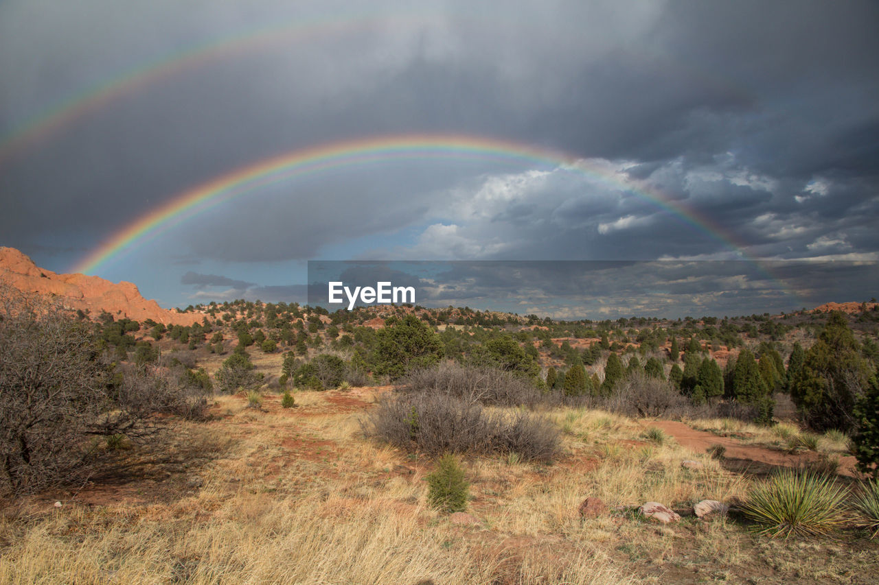 Scenic view of rainbow over mountain against sky