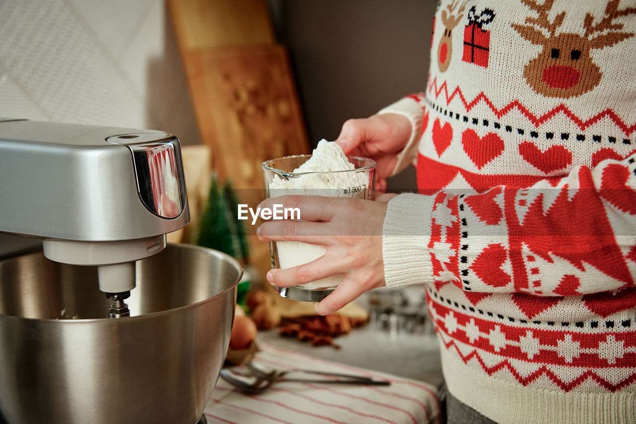 Woman cooking at home kitchen, use electric mixer to preparing dough