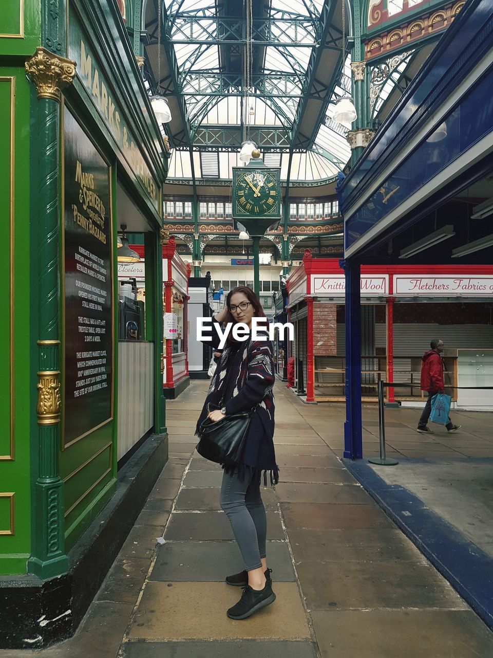 WOMAN STANDING AT RAILROAD STATION