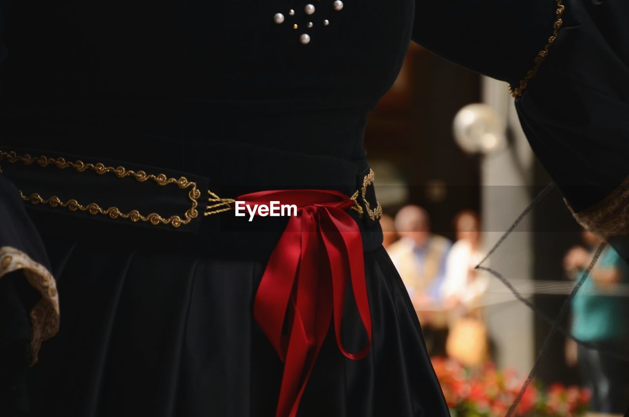 Midsection of woman wearing black dress