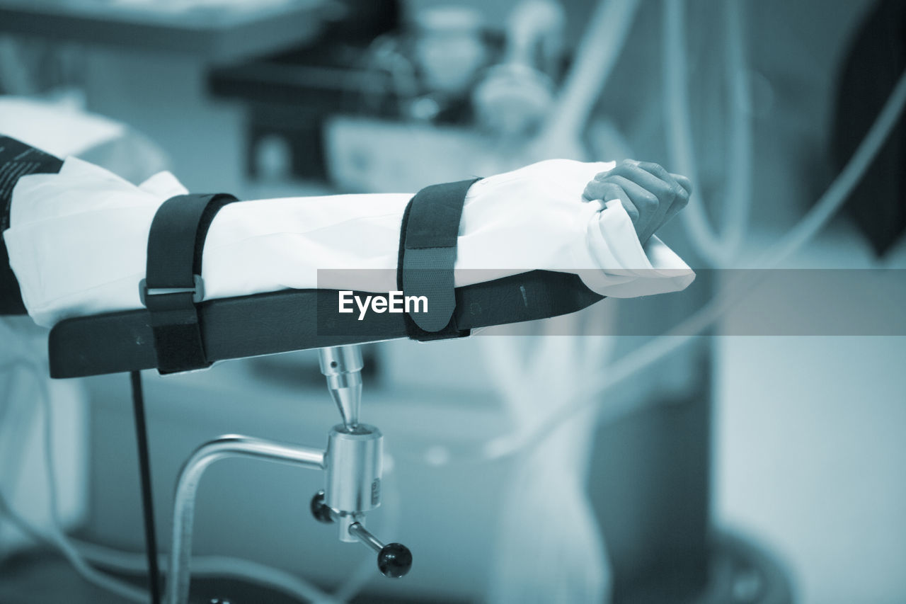 Cropped hand of patient with medical equipment at hospital