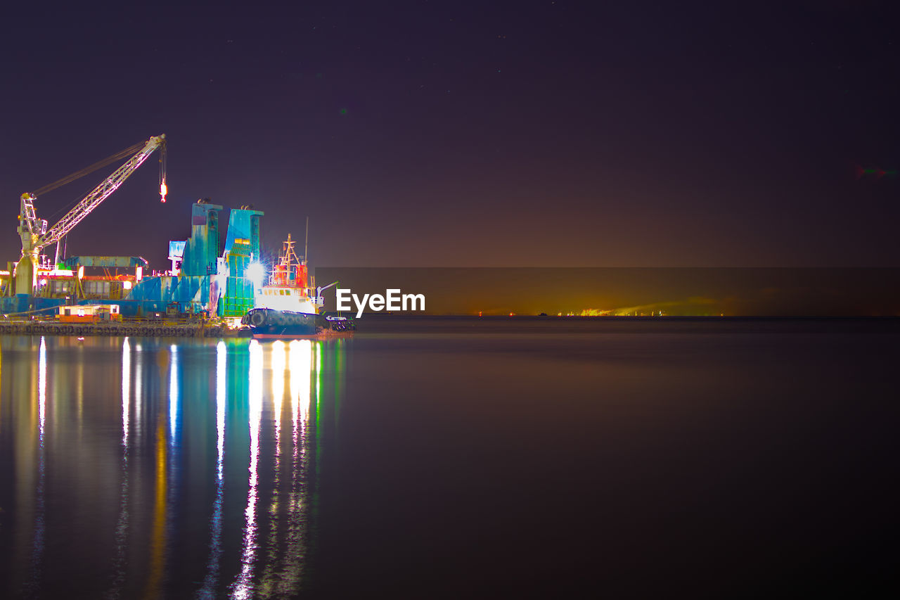 ILLUMINATED SEA AGAINST SKY AT NIGHT