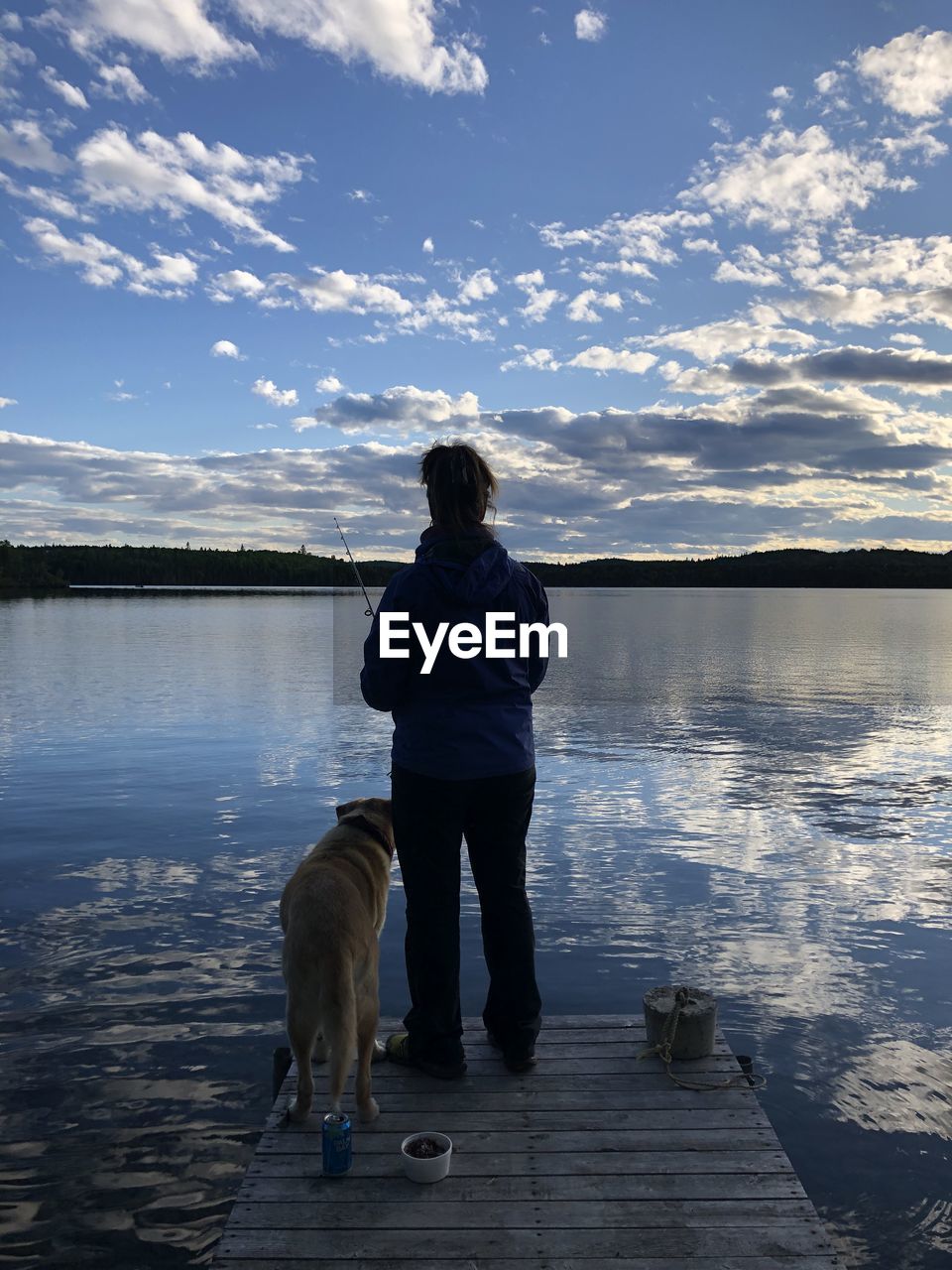 REAR VIEW OF A DOG STANDING ON LAKE