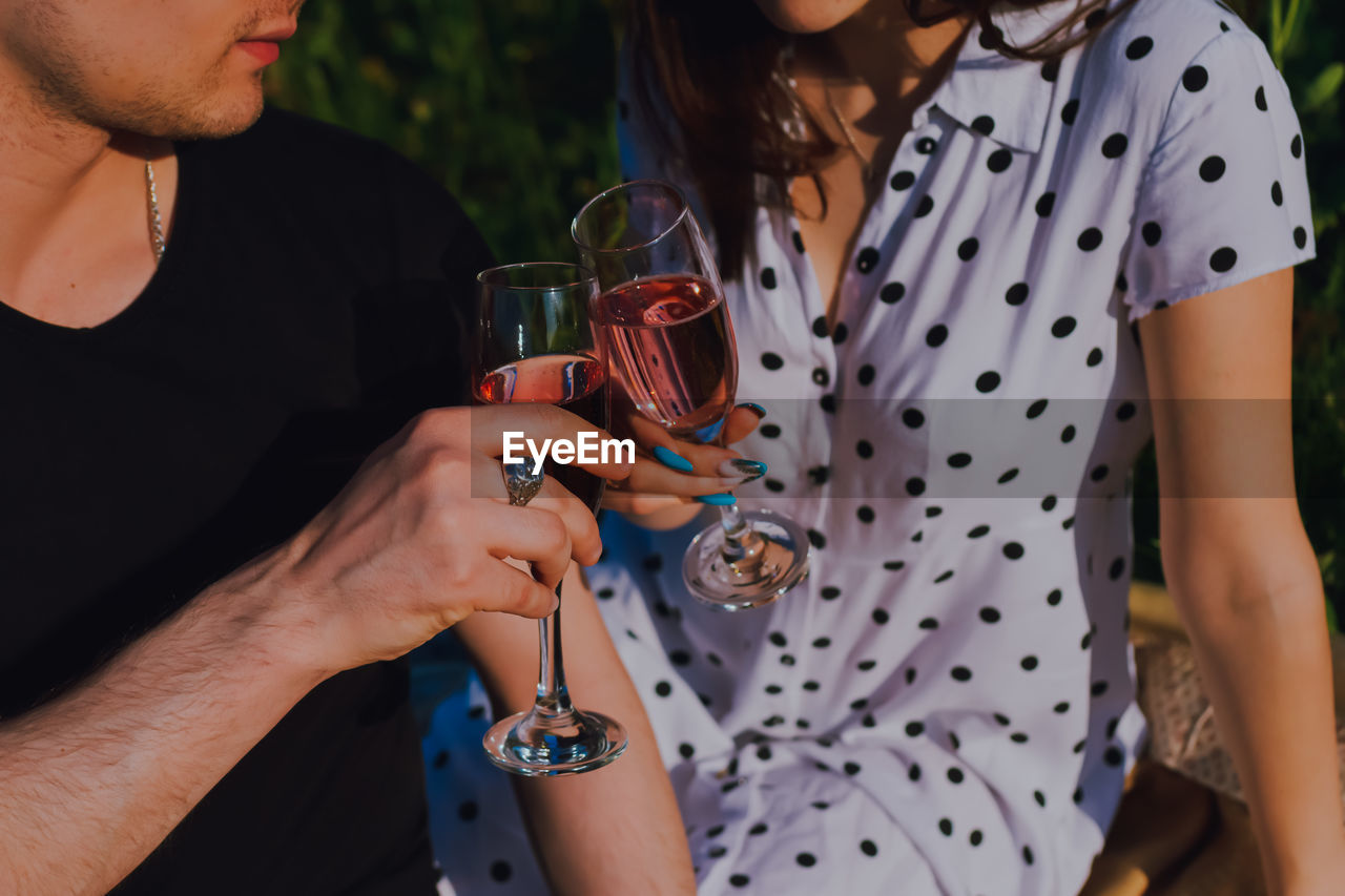 Midsection of woman holding wineglass